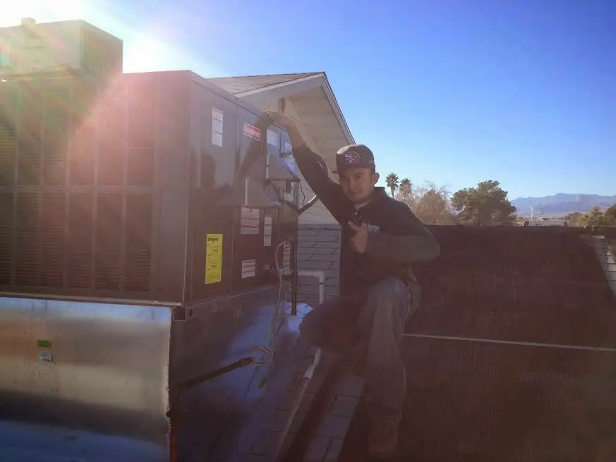 HVAC technician performing Air Duct Repair on a rooftop unit in Jefferson